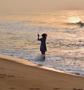 A person enjoys a tranquil moment at the sandy beach of Ouidah, Benin at sunset.